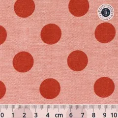 Nahaufnahme des Tilda-Musters „Chambray Dots" in Ginger mit rostroten, ca. 18mm großen Punkten auf meliertem rosa Chambray-Fond, mit Maßband zum Größenvergleich.