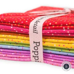 Makroaufnahme des roten Konfetti-Punkte-Musters mit rosa Markenband Poppie Cotton
