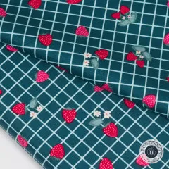 Nahaufnahme des Karomusters mit Erdbeeren und kleinen Blüten, Stoff diagonal gefaltet