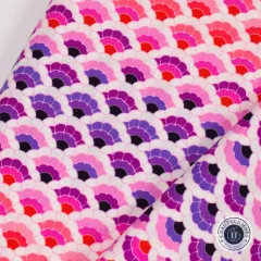 Nahaufnahme des Schuppenmusters mit sichtbarer diagonaler Stofffalte in Rosa-, Rot- und Violetttönen.