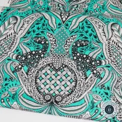 Nahaufnahme des symmetrischen Rapports mit zwei sich gegenüberstehenden Raptor-Figuren im Paisley-Rahmen.