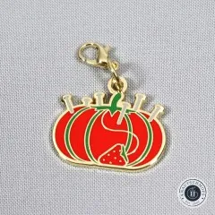Nahaufnahme des Anhängers in Form eines roten Tomaten-Nadelkissens.