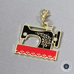 Nahaufnahme des Anhängers in Form einer goldenen Nähmaschine.