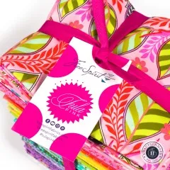 Nahaufnahme der Tula-Pink-Banderole auf dem obersten Fat Quarter mit Blatt- und Blütenmotiv.