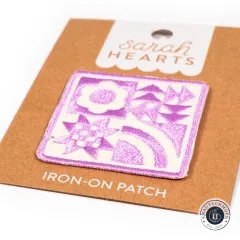 Nahaufnahme des bestickten Patches mit Blume, Stern und Regenbogenmotiv.
