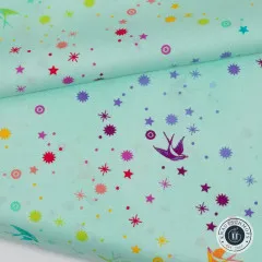 Nahaufnahme des diagonal gefalteten Stoffs „Fairy Dust“ in Mint, bunte Schwalben- und Sternchen-Motive gut erkennbar.