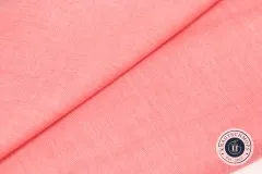 Detailaufnahme einer gefalteten Stoffecke des Coral-farbenen Chambray-Gewebes.