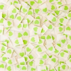 Viele cremefarbene Sarah Hearts Weblabels mit grünem Herz dicht verstreut, Nahaufnahme.