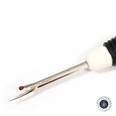 Nahaufnahme der gebogenen Trennklinge mit rotem Fadenknopf am Nahtauftrenner