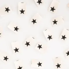 Nahaufnahme mehrerer „Black Star"-Endfalt-Weblabel dicht nebeneinander verstreut.
