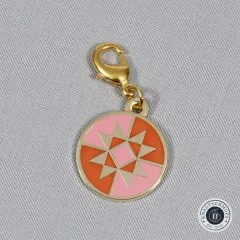 Nahaufnahme des Zipper Charms mit sichtbarem goldenem Karabinerverschluss.