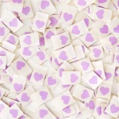 Viele cremefarbene Sarah Hearts Weblabels mit lila Herz dicht verstreut, Nahaufnahme.