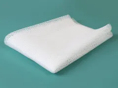Der weiße Netzstoff einmal gefaltet vor türkisfarbenem Hintergrund, zeigt Struktur und Fall des Materials.