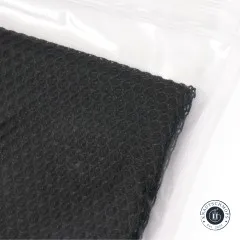 Detailaufnahme des schwarzen Netzstoffs an der Verpackungsecke mit Zip-Verschluss.