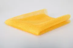 Detailaufnahme des gelben Netzstoffs an der Verpackungsecke mit Zip-Verschluss.