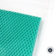 Detailaufnahme des türkisfarbenen Netzstoffs an der Verpackungsecke mit Zip-Verschluss.