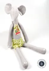 Die fertig genähte Tilda-Elefantenpuppe sitzend mit grün gemusterter Hose und Anhänger.