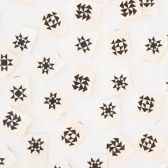 Weitere Nahaufnahme der Quiltblock-Weblabels mit Stern-, Windmühlen- und Blumenmuster in Schwarz-Weiß.