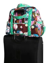 Türkisfarbene Reisetasche mit Lotusblüten-Druck, per Trolley-Schlaufe auf einem Rollkoffer befestigt.