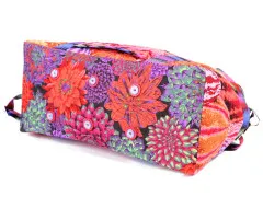 Bodenansicht der Reisetasche mit floralem Muster und dekorativen Knöpfen.