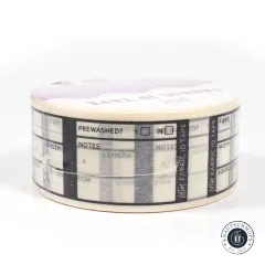 Die Fabric-ID-Tape-Rolle liegend von der Seite fotografiert, sodass die bedruckten Ausfüllfelder rundherum sichtbar sind.