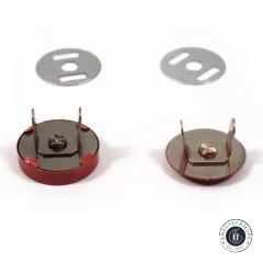 Zwei ziegelrote Druckknöpfe von der Metallrückseite gezeigt mit Splinten, Schraubverschluss und den passenden Unterlegscheiben.
