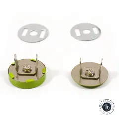 Zwei limettengrüne Druckknöpfe von der Metallrückseite gezeigt mit Splinten, Schraubverschluss und den passenden Unterlegscheiben.