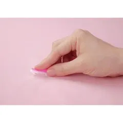 Hand schließt eine pinke Wonder Pin auf rosafarbenem Stoff