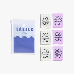 Je drei „Perfectly Imperfect"-Labels in Elfenbein und Flieder ordentlich nebeneinander auf weißem Hintergrund.