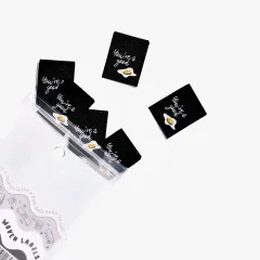 Alle sechs Labels 'You're a Good Egg' ausgebreitet neben der Verpackung mit Aufdruck 'Woven Labels'.