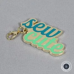 Nahaufnahme des Anhängers mit dem Schriftzug 'sew cute' in Türkis und Blau, aus einem anderen Blickwinkel.
