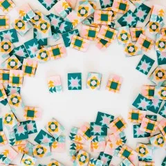Die vier Sarah-Hearts-Weblabels „Quilt Block" in unterschiedlichen Quilt-Musterfarben nebeneinander aufgereiht, umgeben von weiteren verstreuten Labels.