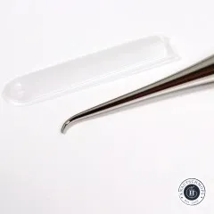 Nahaufnahme der gebogenen Metallspitze der Ahle neben der durchsichtigen Schutzkappe.