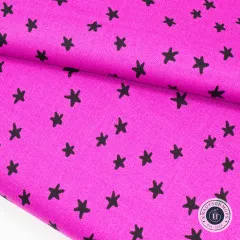 Gefalteter pinker Baumwollstoff mit schwarzen Sternen in Nahaufnahme
