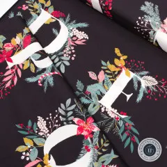 Diagonal gefalteter Stoff mit Blick auf die floral verzierten Panel-Buchstaben D und E.