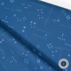 Diagonal gefalteter Stoff mit Blick auf das feine Stichmuster in Indigo Sky.