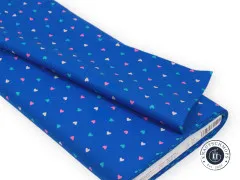 Der blaue Herzchen-Stoff gefaltet und gestapelt, mit sichtbarem Adressetikett.