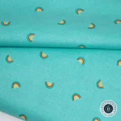 Der Stoff sanft gefaltet, einzelne Mini-Regenbogen-Motive sind in der Nahaufnahme gut erkennbar.