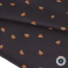 Der Stoff sanft gefaltet, einzelne Mini-Regenbogen-Motive sind in der Nahaufnahme gut erkennbar.