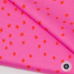 Diagonal gefalteter pinkfarbener Stoff mit Nahaufnahme der roten Sterne.