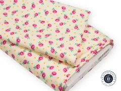 Gefalteter Stoffballen des Curiouser-and-Curiouser-Stoffs Baby Buds Sugar mit sichtbarem Etikett und Artikelnummer PWTP167.