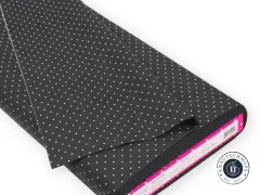 Gefalteter Stoffballen mit Punkte-Muster „Tiny Dots" in Carbon und Etikett am Wickelkern.