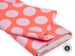 Gefalteter Stoffballen des Designs „Dinosaur Eggs“ in Blush mit sichtbarem Herstelleretikett.