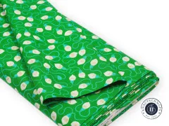Zusammengelegter Stoffballen mit grünem Lichterketten-Druck auf weißem Hintergrund