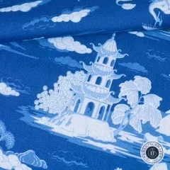 Gefalteter Stoffballen mit weißer Pagode auf Inselchen zwischen Wolkenmotiven auf Marineblau