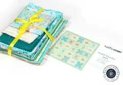 Gebuendeltes Fat-Quarter-Stoffpaket in Mint- und Tuerkistoenen neben dem Double-Paradise-Schnittmuster von Hello Hobby