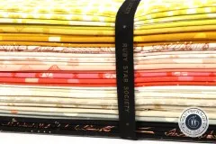 Detailansicht der gestapelten Stoffe mit Gold-Metallic-Print in Gelb-, Rosa- und Koralltönen