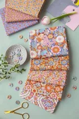 Die Wallflower-Stoffe in einem dekorativen Flatlay mit Schere, Knöpfen und einer Tulpe.