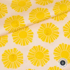 Diagonal gefaltete Stoffecke zeigt Musterverlauf der gelben Sonnenmotive auf Naturweiß.