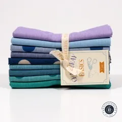 Nahaufnahme der gefalteten Stoffkanten in Lila, Blau, Petrol und Smaragdgrün mit dem Baumwollband „Tilda Quilt Collection".